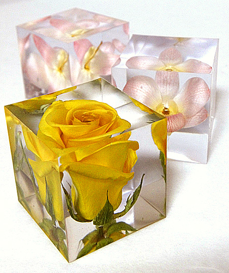 バラとデンファレのドライフラワーを封閉じ込めたキューブ型のレジン作品の画像