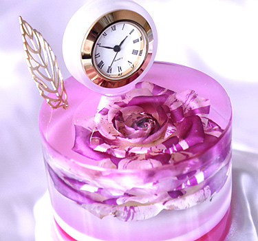 エポキシレジンにバラのドライフラワーを封入したスイーツのようなデザインの置時計の画像